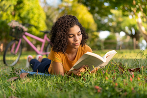 Teen Reading on Grass